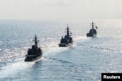 Arleigh Burke-class guided-missile destroyer USS Mustin (DDG 89) transits in formation with Japan Maritime Self-Defense Force ships JS Kirisame (DD 104) and JS Asayuki (DD 132) during bilateral training in South China Sea on April 21, 2015.
