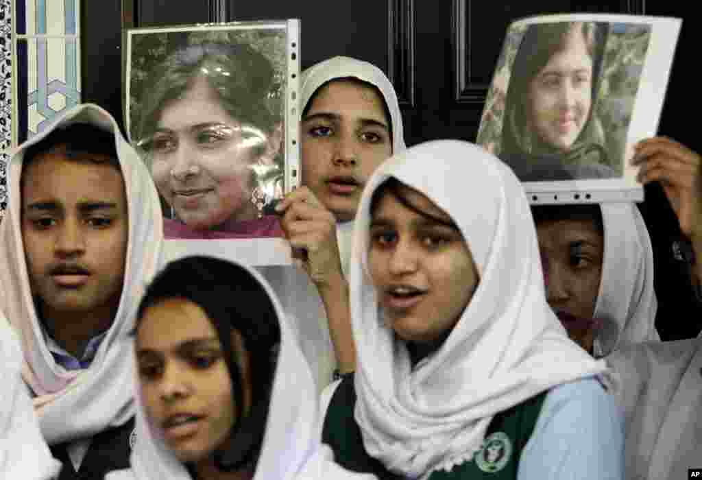 Pakistani students sing as they hold pictures of Malala Yousufzai during a tribute at the Pakistani Embassy in Abu Dhabi, United Arab Emirates, October 15, 2012.