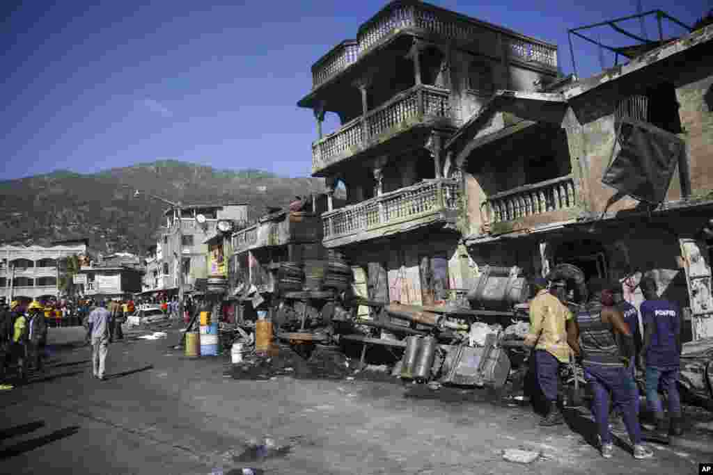 Firefighters stand next to what remains of a truck that was carrying gasoline after it overturned and exploded in Cap-Hatien, Haiti.&nbsp;The explosion engulfed cars and homes in flames, killing more than 50 people and injured dozens of others.&nbsp;