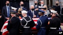 U.S. President Joe Biden and first lady Jill Biden place their hands over their hearts as casket of former Sen. Bob Dole, who died on Sunday, is moved by a military joint forces bearer team, during a congressional ceremony to honor Dole, who lies in state