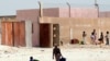 Quelques personnes devant une ancienne école appelée par les locaux "Guantanamito", transformée en 2006 en centre de détention pour immigrants clandestins dans la ville portuaire de Nouadhibou, Mauritanie, 9 octobre 2008.