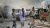 FILE - A Somali soldier helps a civilian who was wounded in a blast in the capital of Mogadishu, Somalia, Saturday, Oct. 14, 2017. 