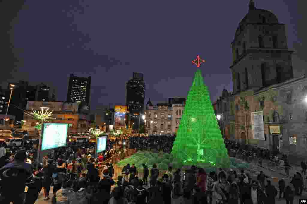 People enjoy the eco-friendly Christmas tree set up at the Basilica de San Francisco explanade in La Paz, Bolivia. The tree of 14 meters high was made with some 50,000 plastic bottles, Dec. 18, 2013.