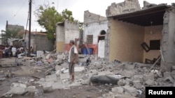 FILE - A man stands on the wreckage of a house destroyed by a Saudi-led airstrike in Yemen's Red Sea port city of Houdieda, Dec. 21, 2015.