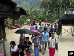FILE - Karen refugees leave after a church service at Mae La refugee camp in Ta Song Yang district of Tak province, northern Thailand, April 12, 2013.