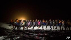 Para pengungsi dan migran dari berbagai negara Afrika, dudud di atas perahu karet yang penuh sesak, meninggalkan wilayah perairan Libya dini hari, 5 Maret 2017.