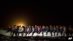 Refugees and migrants from many different African nationalities sit aboard an overcrowded rubber boat leaving Libyan territorial waters early March 5, 2017. A similar boat carrying more than 100 people sank off the coast of Libya earlier this week and dozens are missing.