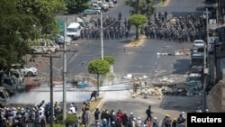 Army officers intervene during a protest against the military coup in Yangon, Myanmar, March 2, 2021. Picture taken from behind a window. REUTERS/Stringer