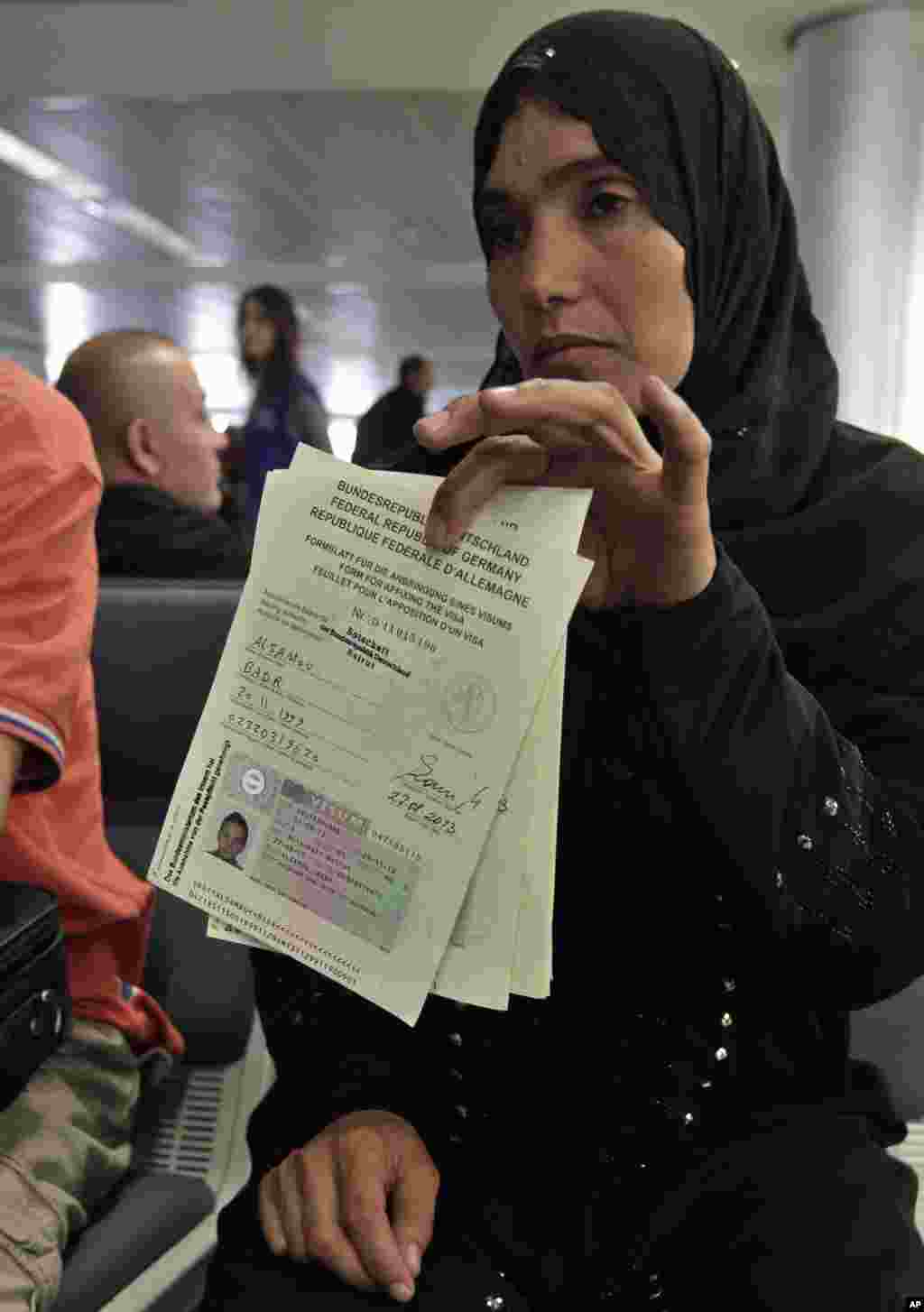 A Syrian refugee shows her immigration papers before boarding a flight to Germany for temporary relocation, at Rafik Hariri International Airport in Beirut, Lebanon, Sept. 11, 2013.