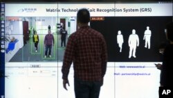 FILE - Watrix employees demonstrate their firm's gait-recognition software at their company's offices in Beijing, Oct. 31, 2018.