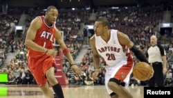 Defendiendo a los Atlanta Hawks, Tracy Mc Grady trata de detener al brasileño de los Toronto Raptors (otr de sus equipos), Leandro Barbosa.