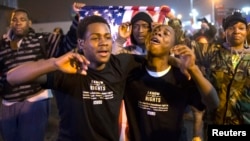 Protesters, demanding the criminal indictment of a white police officer who shot dead an unarmed black teenager in August, shout slogans while marching through a suburb in St. Louis, Missouri, Nov. 23, 2014. 