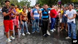 Cubans disrupt traffic on a street near Ecuador's embassy, expressing discontent with new rules requiring Cubans to have a visa to visit the South American country, in Havana, Cuba, Nov. 28, 2015.