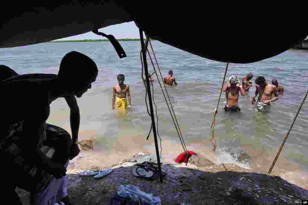 Bangladeshi men wash themselves in the sea near a temporary shelter in Langsa, Aceh province, Indonesia, May 19, 2015. Indonesia&#39;s foreign minister said that her country has &quot;given more than it should&quot; to help hundreds of Rohingya and Bangladeshi migrants stranded on boats by human traffickers.