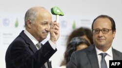 法國外長法比尤斯（左）敲打小槌，宣佈全球氣候協議獲得一致通過。旁為法國總統奧朗德。