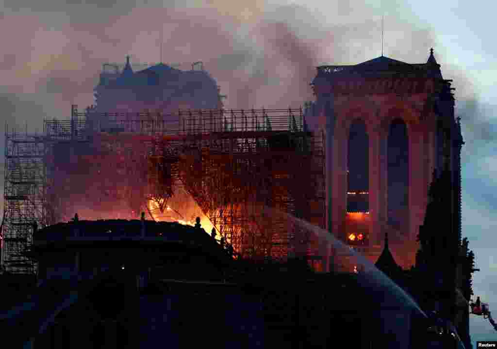 Firefighters douse flames of the burning Notre Dame Cathedral in Paris, France, April 15, 2019. 