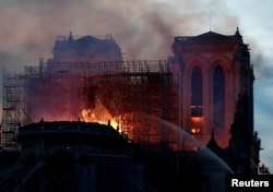 Firefighters douse flames of the burning Notre Dame Cathedral in Paris, France, April 15, 2019.