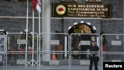 Polisi anti huru-hara Turki menjaga kantor pemerintah kota Sur setelah pemecatan walikota yang dituduh pro PKK, Minggu (11/9). 