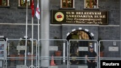 A riot police officer stands guard in front of Sur municipality office, following the removal of the local mayor from office after he was deemed to support Kurdish militants, in Diyarbakir, Turkey, Sept. 11, 2016. 