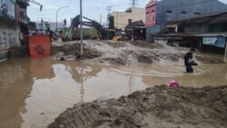 Sebuah alat berat digunakan untuk mengeruk material lumpur yang menutupi badan jalan akibat banjir bandang di Masamba, Luwu Utara, Sulawesi Selatan, 14 Juli 2020. (Foto: Tim SAR UNHAS Makassar)