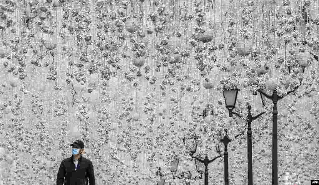 A man wearing a face mask walks along a street decorated with illuminations in central Moscow during a strict lockdown in Russia to stop the spread of the COVID-19.