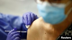 Vatrogasac prima dozu cjepiva Pfizer BioNTech COVID-19 "Comirnaty" u centru za cijepljenje u Rezeu kod Nantesa u sklopu kampanje cijepljenja protiv koronavirusne bolesti (COVID-19) u Francuskoj, 6. svibnja 2021. REUTERS / Stephane Mahe