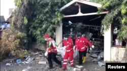 Bodies are carried out of a house on Talise beach, Central Sulawesi, Indonesia, Oct. 3, 2018, in this still image obtained from a social media video.