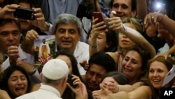 Pope Francis is cheered by faithful as he arrives in the Paul VI hall at the Vatican, Aug. 5, 2015.
