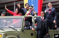 Venezuela's President Nicolas Maduro and first lady Cilia Flores wave during a military parade commemorating the country's Independence Day in Caracas, Venezuela, July 5, 2017.