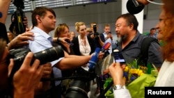 Dissident Chinese artist Ai Weiwei is surrounded by media as he arrives at the airport in Munich, Germany, July 30, 2015.
