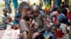 In this photo taken Sept. 16, 2016, a young girl holds a child at a UNICEF clinic for severely malnourished children in Aweil, South Sudan.