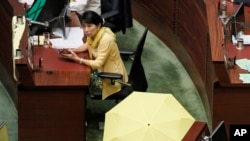 Pro-democracy lawmaker Claudia Mo displays a yellow umbrella before an election for reform proposals in Hong Kong, Thursday, June 18, 2015.