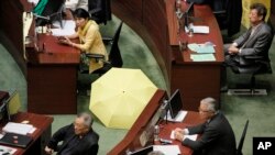 Pro-democracy lawmaker Claudia Mo displays a yellow umbrella before an election for reform proposals in Hong Kong, Thursday, June 18, 2015.