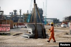A construction worker assists with moving building materials on a lift at the Dangote Oil Refinery under construction, in Ibeju Lekki district, on the outskirts of Lagos, Nigeria, July 5, 2018.
