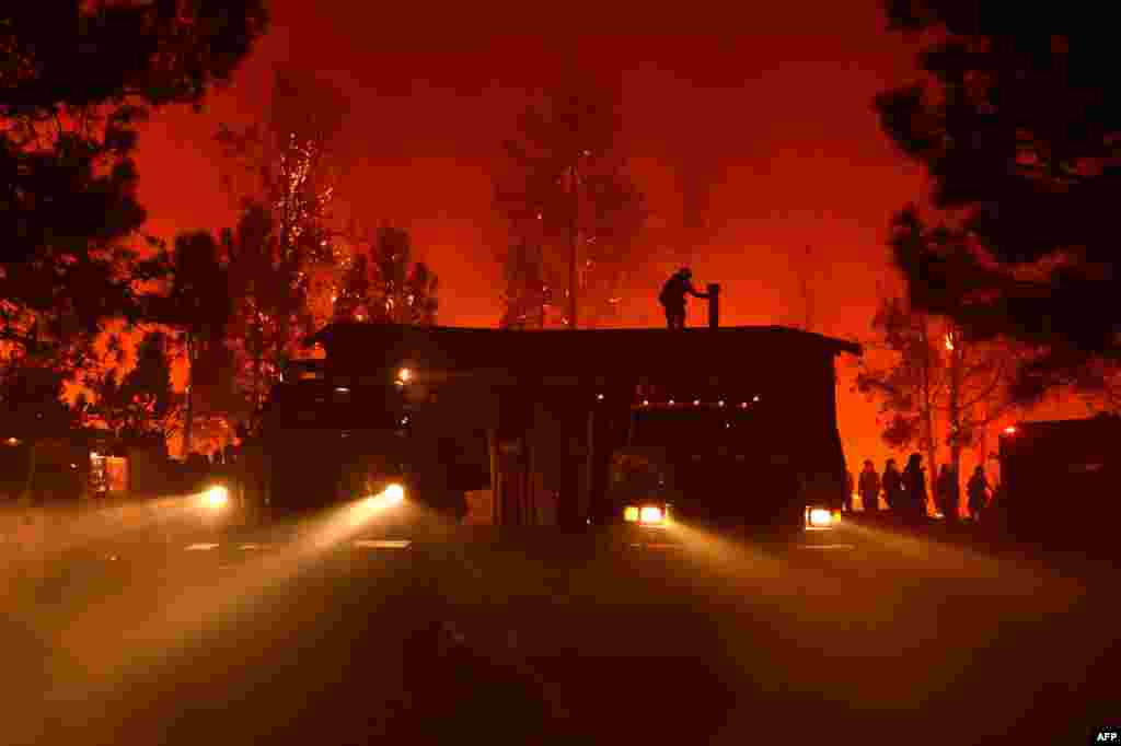 미국 캘리포니아주 로마프리에타 인근 산타크루즈 산맥에서 발생한 산불로 위험에 처한 소방서 주변에서 소방대원들이 피해방지 작업을 진행하고 있다.
