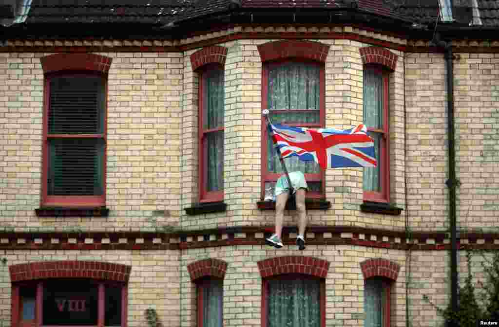 The legs of a mannequin hang out of the window of a house on a residential street in Brighton, Britain, Sept. 18, 2018.