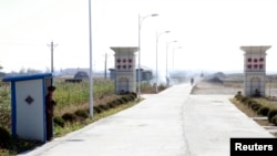 FILE - A North Korean soldier looks out from a sentry as he stands guard at an entrance to the Hwanggumpyong Economic Zone near the North Korean town of Sinuiju, opposite China's border city of Dandong.