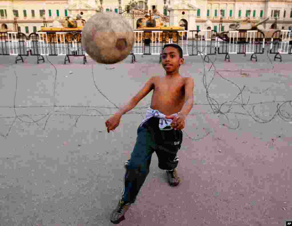 A boy plays soccer in front of army tanks at Abdeen Palace Museum in Cairo on Thursday. (Reuters/Amr Abdallah Dalsh)