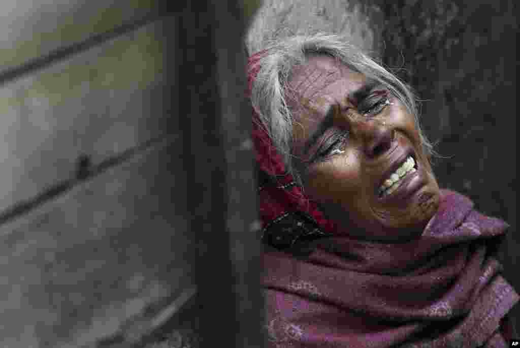 The mother of Ram Singh, the man accused of driving the bus on which a 23-year-old student was gang raped in December 2012, cries as she speaks to journalists outside the family's home in New Delhi. Police confirmed that Singh, one of the men on trial for his alleged involvement in the attack, committed suicide in an Indian jail Monday, but his lawyer and family allege he was killed.