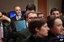 Syria U.N. Ambassador Bashar Ja'afari, second from left, listen during a press briefing after attending closed Security Council meetings on Syria at U.N. headquarters, Feb. 19, 2016.
