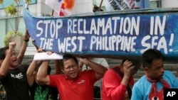 Người Philippines biểu tình trước lãnh sự quán Trung Quốc ở Makati mang theo một chiếc thuyền sơn khẩu hiệu phản đối hành động của Trung Quốc ở Biển Đông, ngày 3/7/2015.