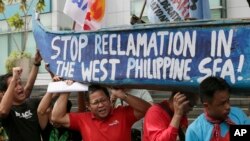 菲律宾人在中国领事馆前示威，他们抬着的船上漆着标语“停止在西菲律宾海人工造岛”（2015年7月3日）