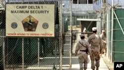 FILE - U.S. military guards enter the Camp Delta military-run prison, at the Guantanamo Bay U.S. Naval Base, Cuba, June 27, 2006. 