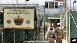 FILE - U.S. military guards enter the Camp Delta military-run prison, at U.S. Naval Station Guantanamo Bay, Cuba, June 27, 2006. 