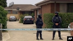 In this image made from video, police stand guard outside a raided property connected to a foiled terror attack, Nov. 20, 2018, in Melbourne, Australia. 