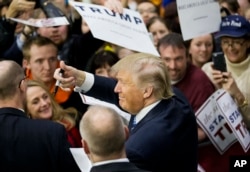 Republican presidential candidate Donald Trump gestures to the crowd as he signs autographs at a campaign event at Plymouth State University Sunday, Feb. 7, 2016, in Plymouth, N.H.