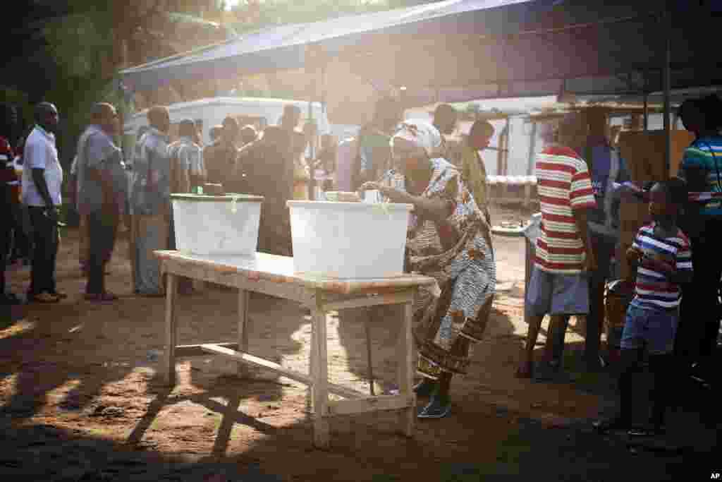A woman casts her vote for the presidential election at a polling station in Accra, Ghana, December 7, 2012. 