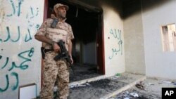 Một binh sĩ Libya đứng canh ở khu vực trước đây là Lãnh sự quán Mỹ đã bị đốt 