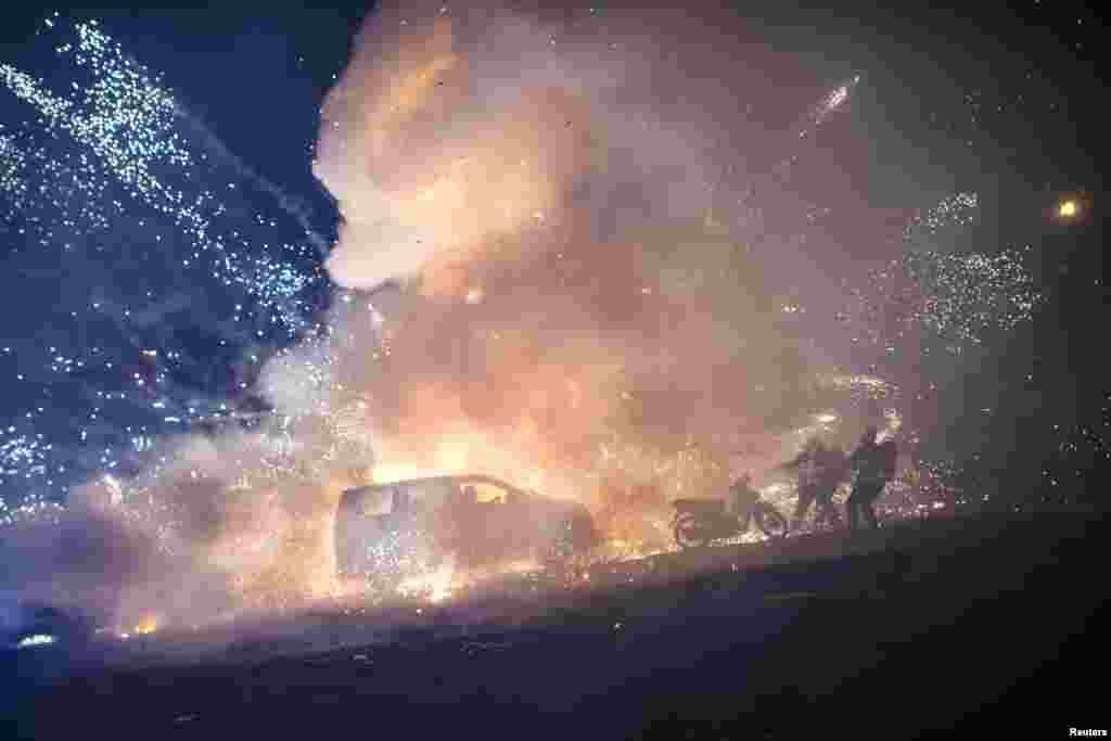 Firefighters try to control a blaze after a fireworks-laden hot-air balloon ignited while next to a car during the closing ceremony of the Tazaungdaing Festival at Taunggyi, in Myanmar&#39;s northeastern Shan State, Nov. 15, 2016.