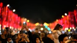 People celebrate the New Year's Eve on the Champs Elysees avenue, in Paris, Dec. 31, 2021.